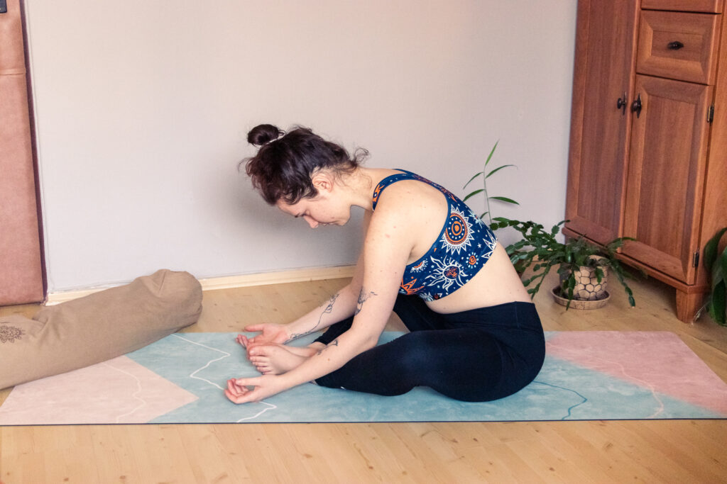 young yogini performing yin yoga butterfly pose with correct head and neck alignment